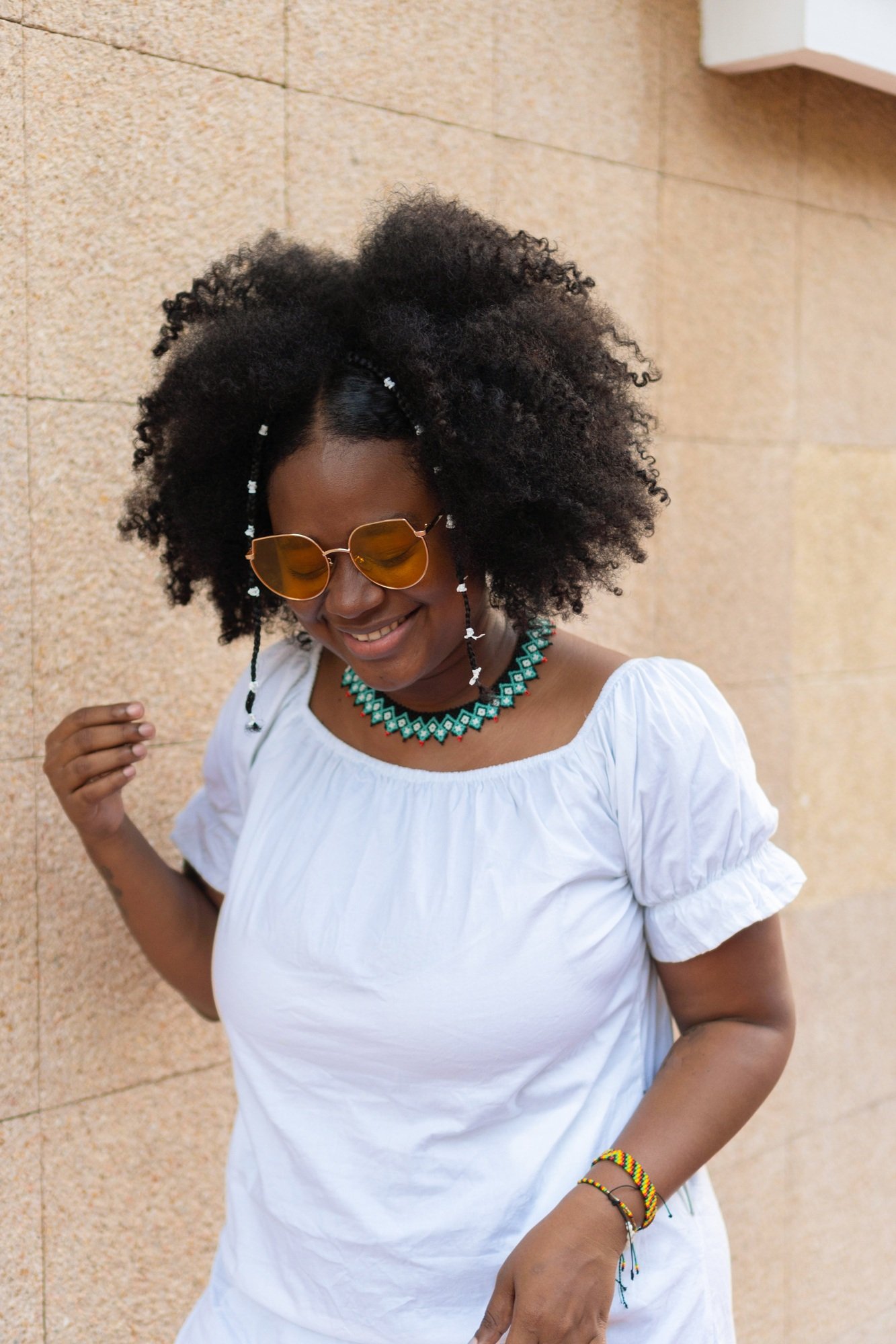 Latina woman with afro hair, laughing in park